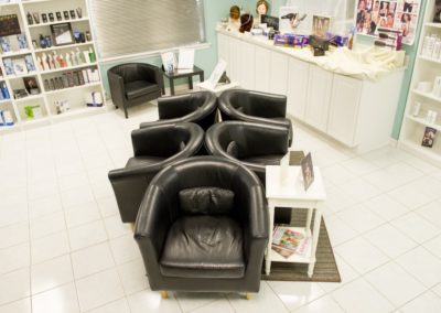 The waiting room with six black chairs at the front lobby at Details Salon & Spa